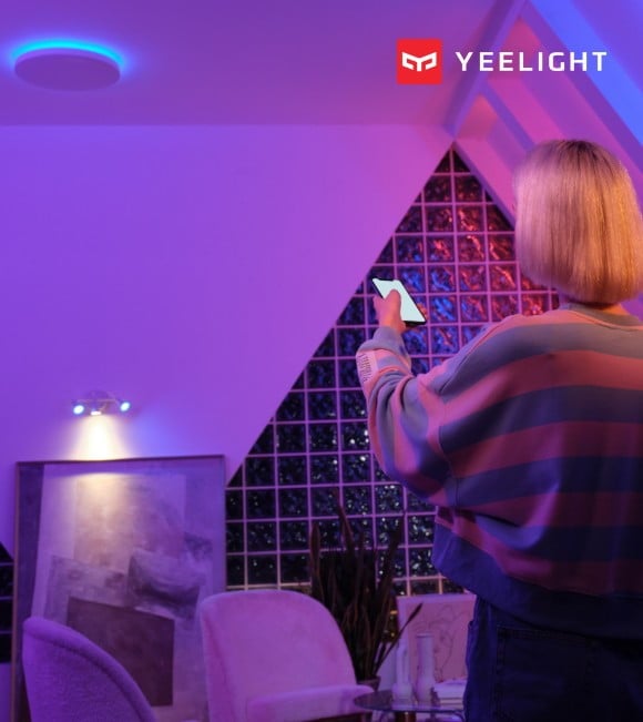 kobieta w pokoju oświetlonym kolorową lampą sufitową